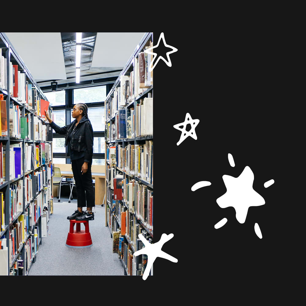 Student putting books on library shelf