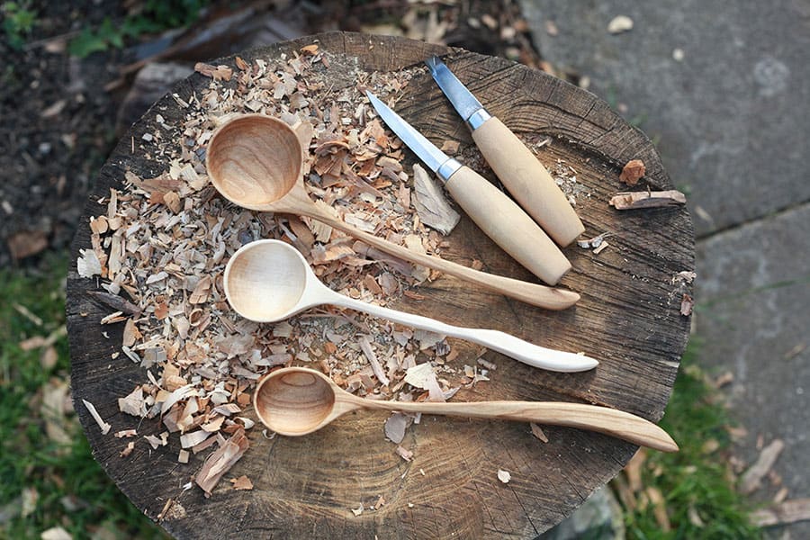3 wooden spoons and two carving tools.