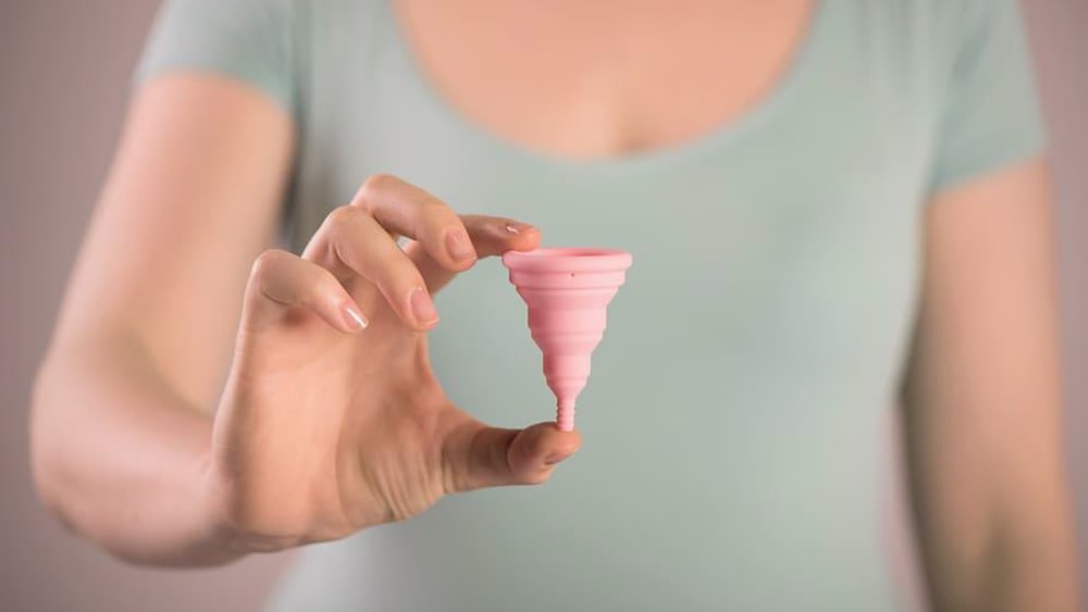 woman holding a menstrual cup