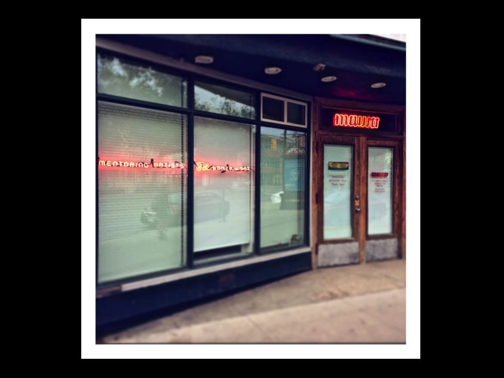 an image of a shop displaying red neon lights that read 'mentoring artists'