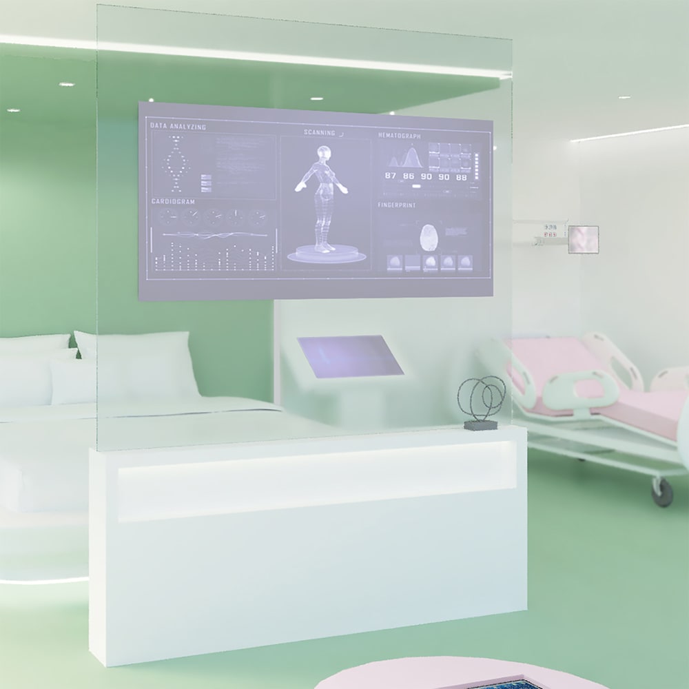 Image shows a design of a room, which includes a double bed as well as comfy wheeled stretcher. There is a large screen at the end of the bed which monitors the patient and keeps them updated with their latest diagnostic treatment. The room is decorated in green.