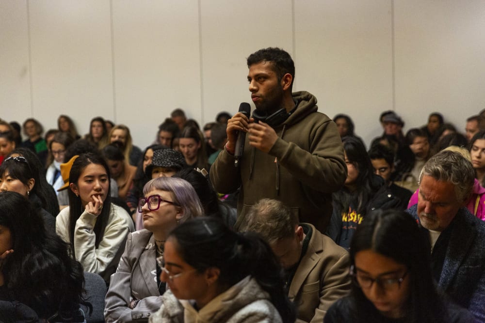 Guest standing up speaking into a microphone. 