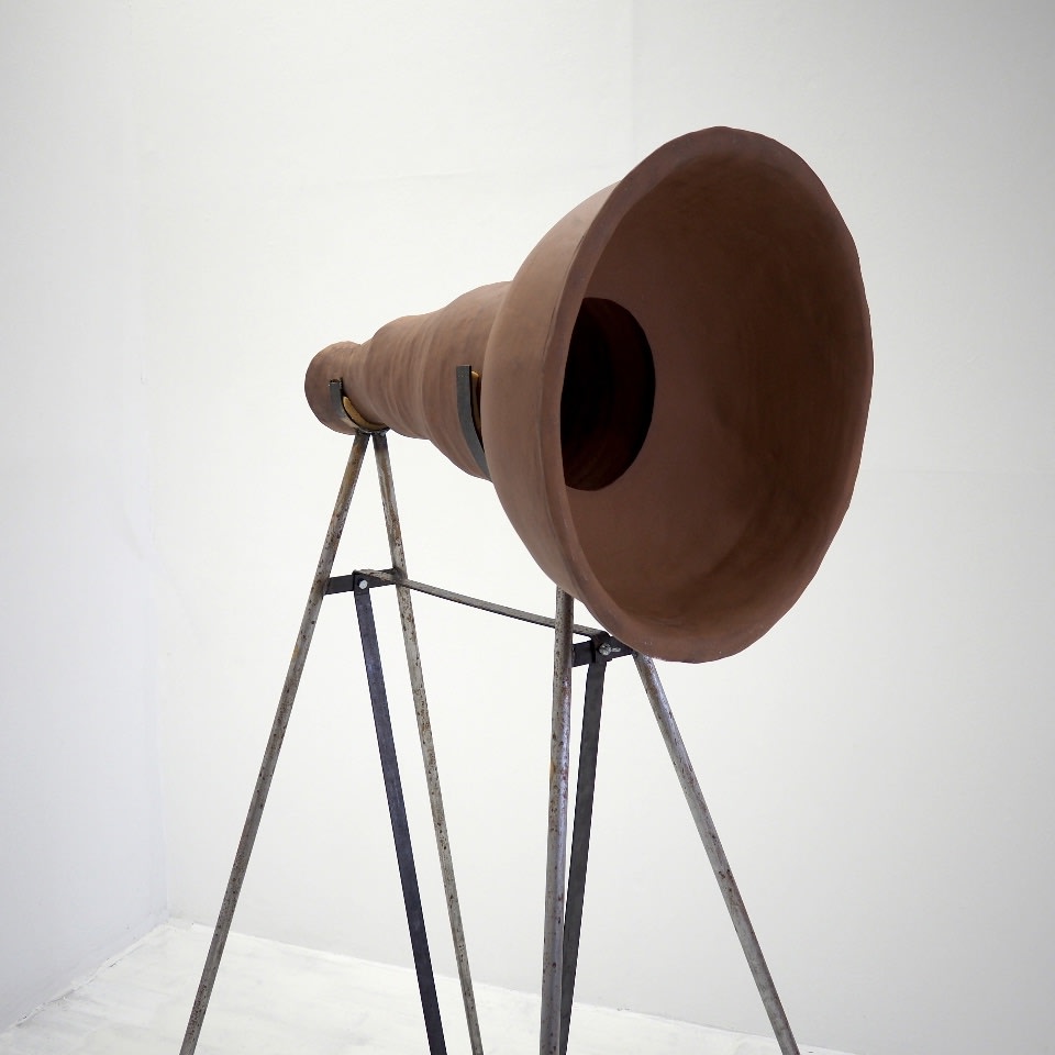 Ceramic sculpture, a handmade ceramic megaphone made from clay is displayed on a metal frame 