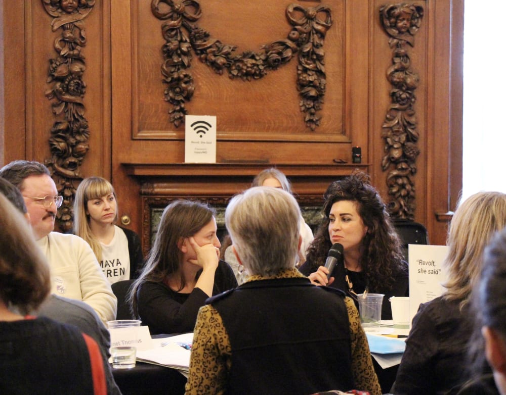 Dr Azadeh Fatehrad holding the mic at a table discussion