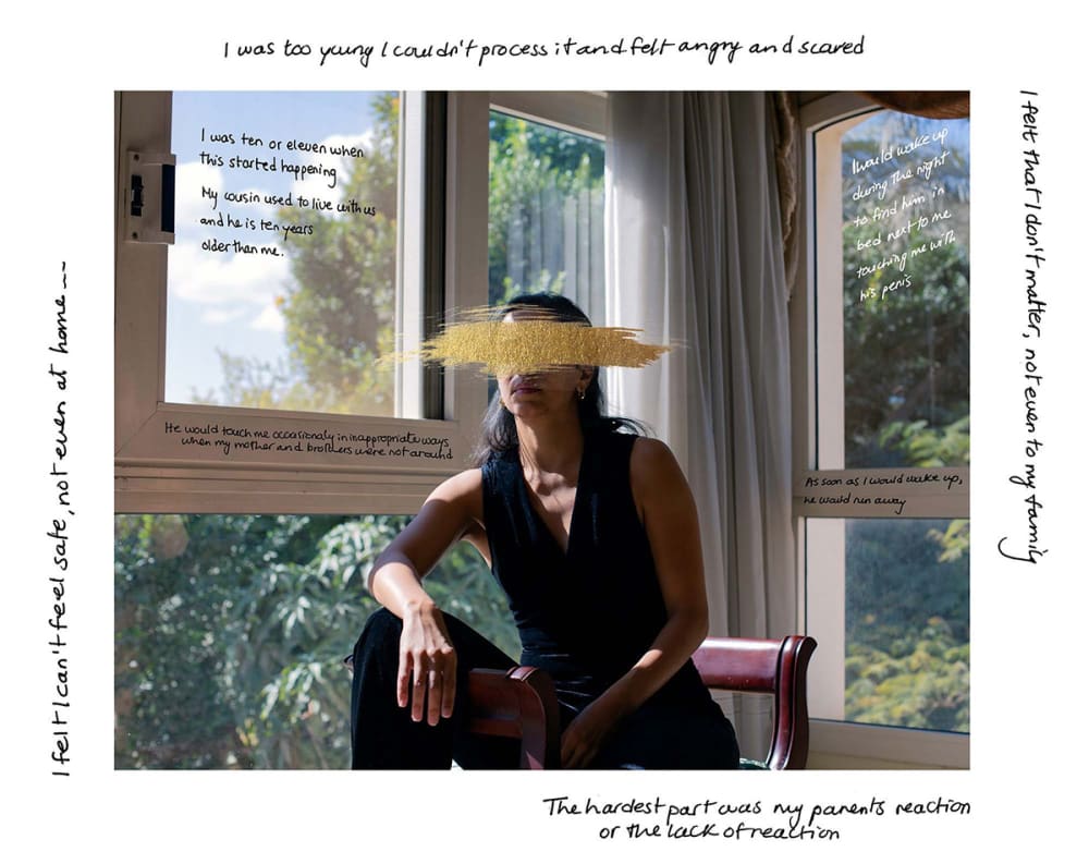 A photograph of a woman sitting by a window.