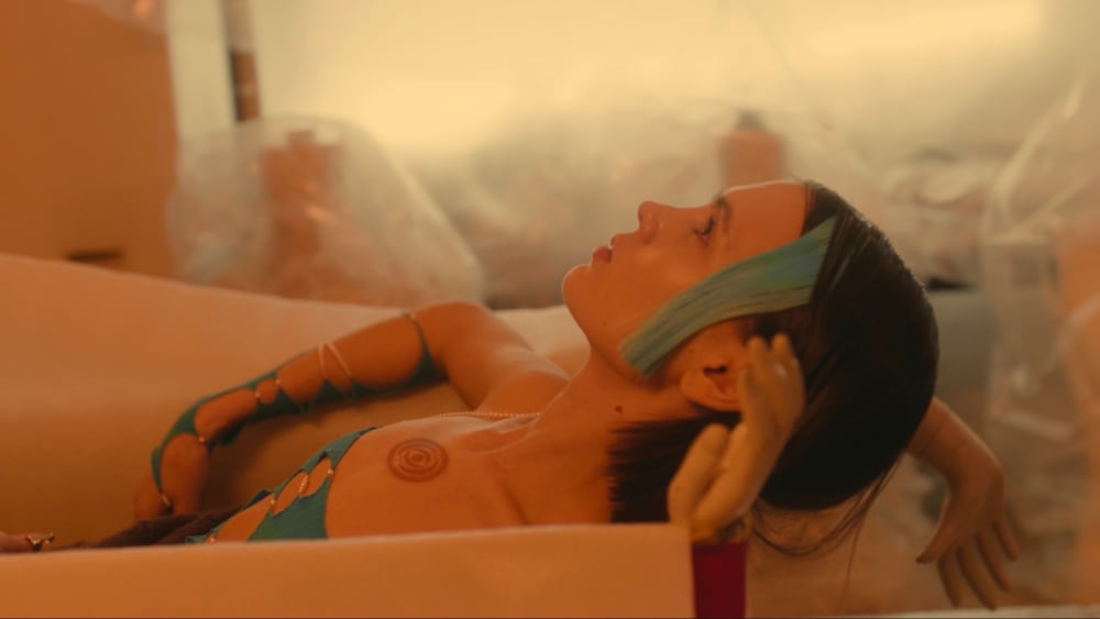 Tenet the cyborg facing up in a cardboard box with mannequin arms