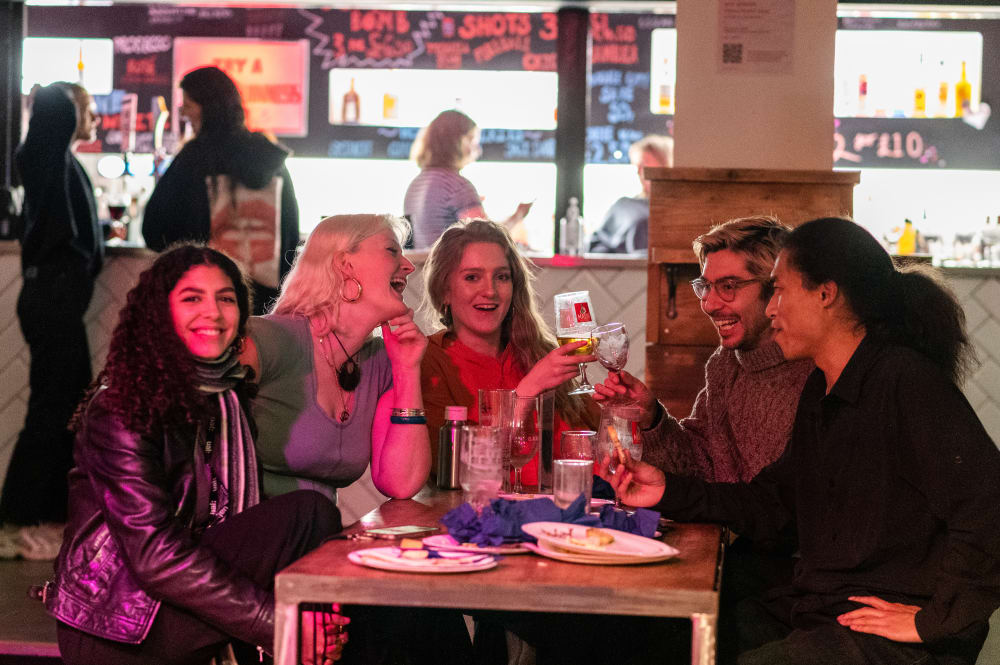 a group of students sat drinking around a table