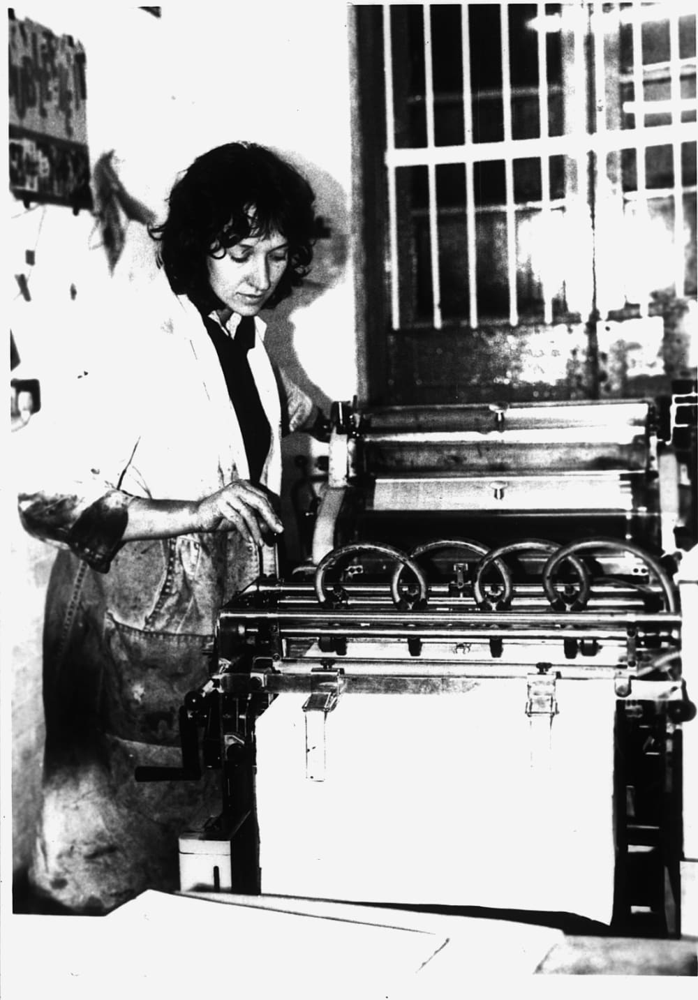 Black and white picture of Nicola Palmer at a printing press in the 1980s