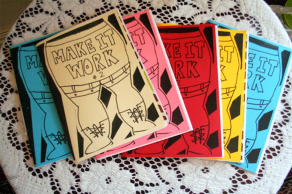 multiple copies of a colourful zine that reads 'make it work', laid out on a table