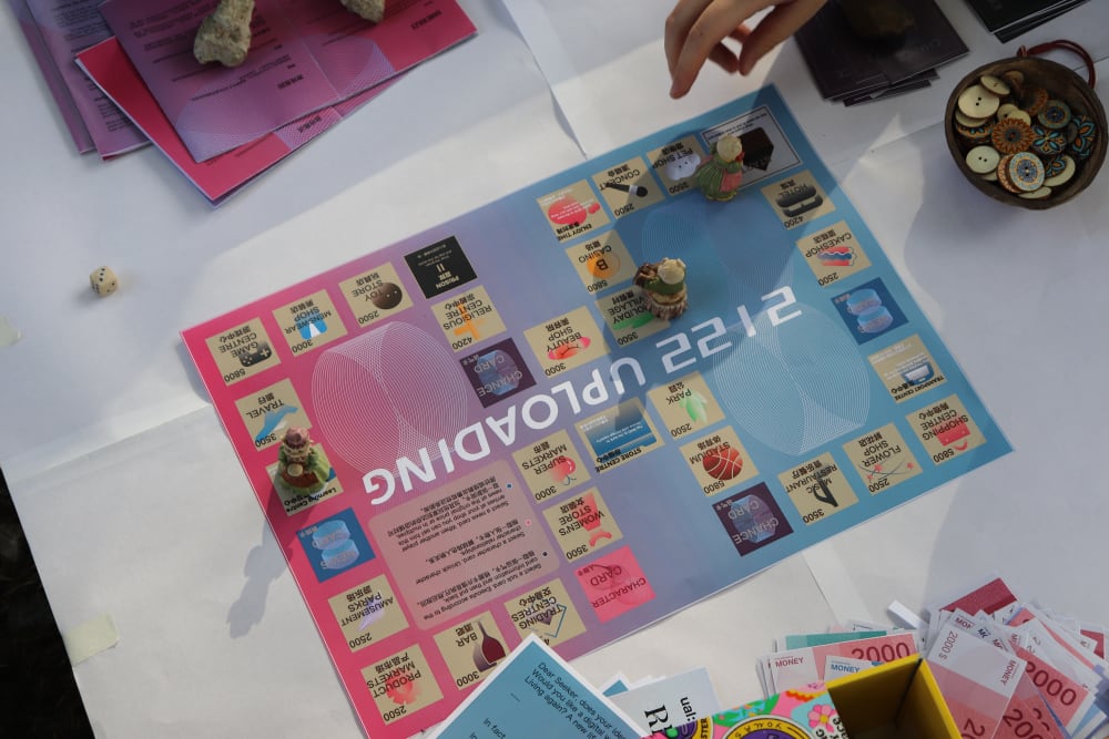 hands interacting with artwork on the floor