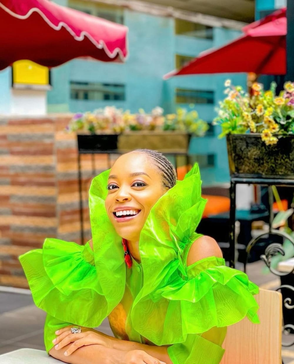 a woman in a neon green dress smiling