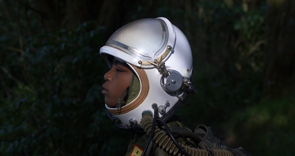 A side profile photo of a young boy wearing a helmet