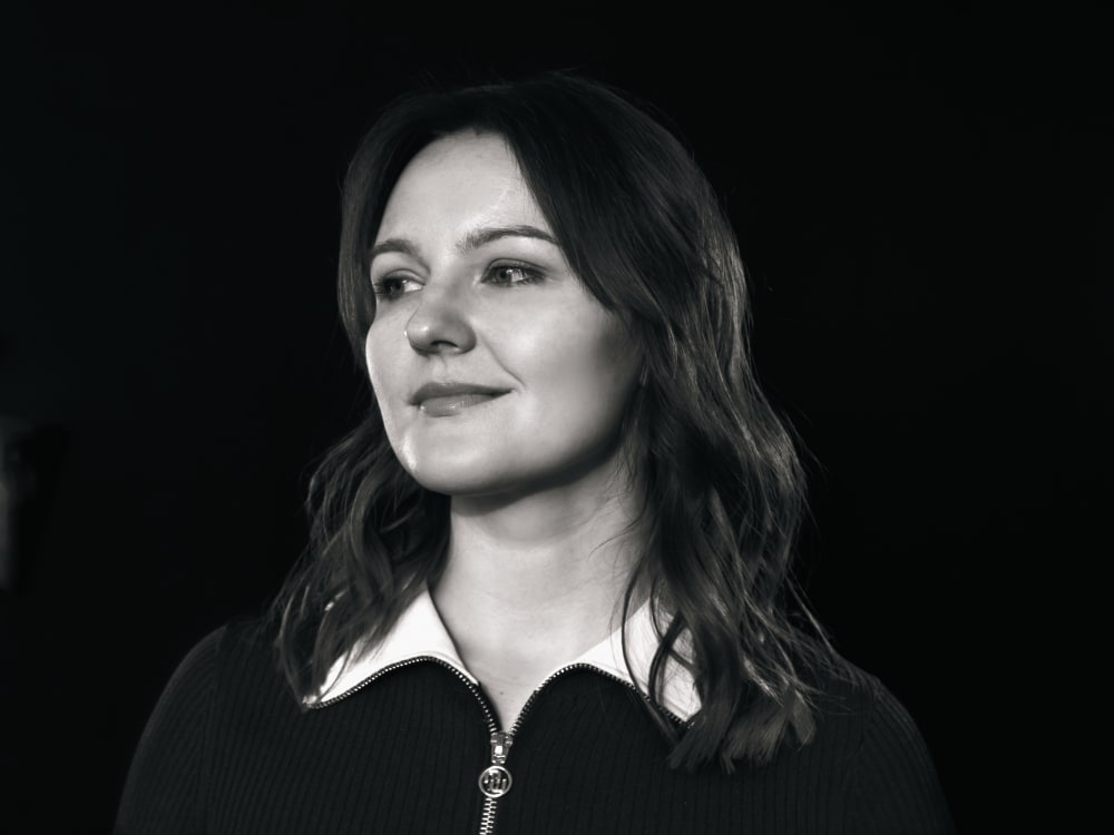 Black and white headshot of Ieva. She's looking off to the left