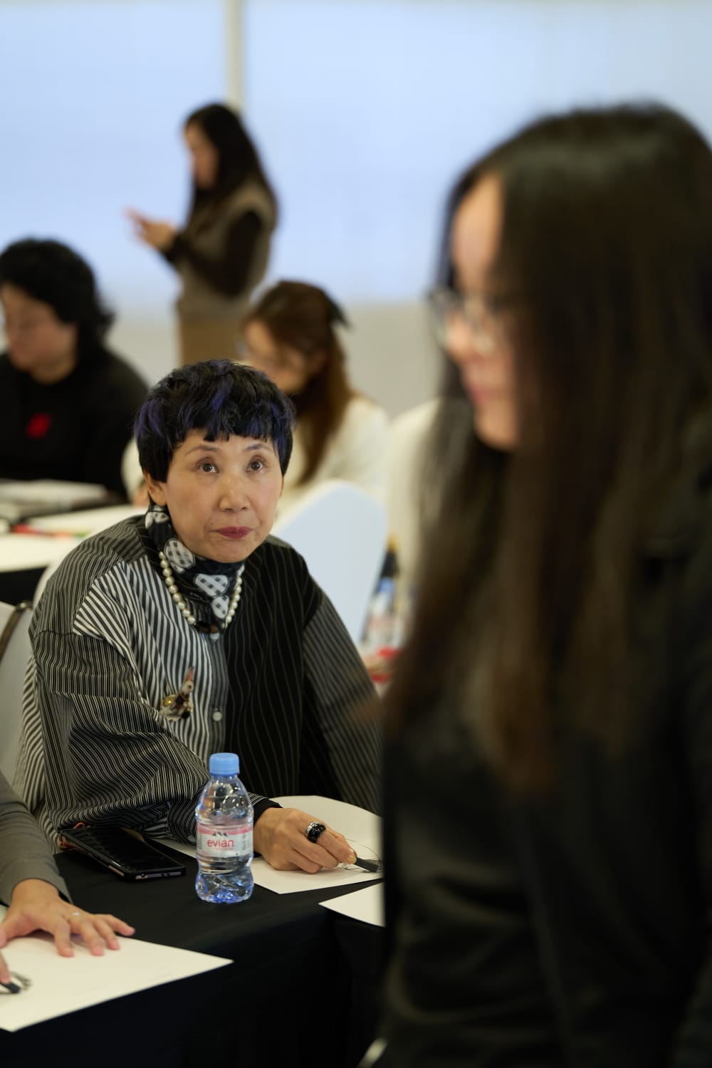 A woman focusing on the model whilst drawing