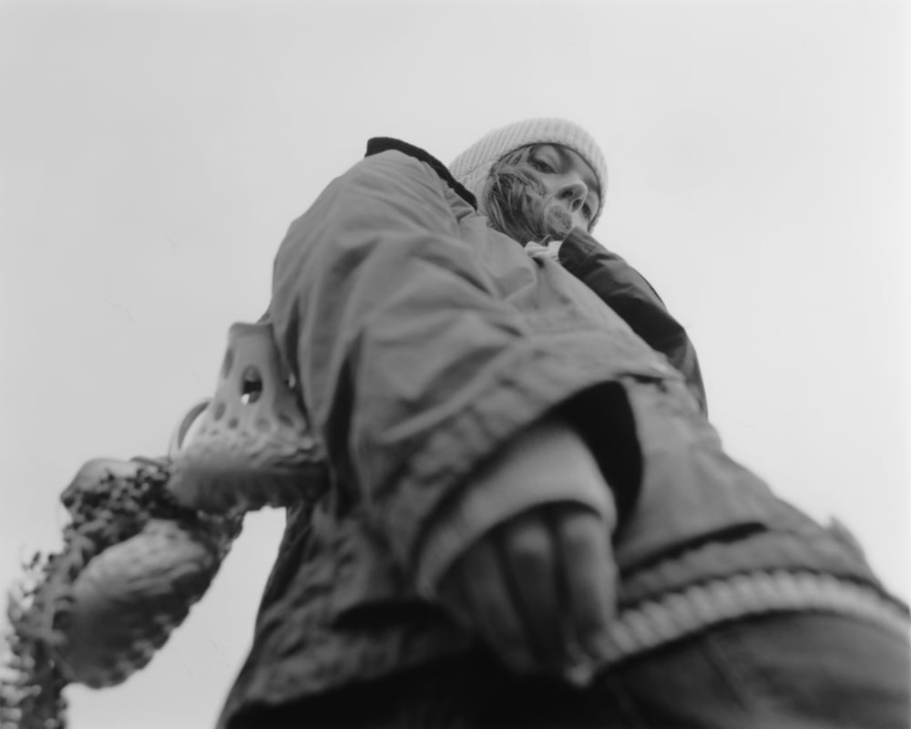 Black and white low angle image of model in balaclava