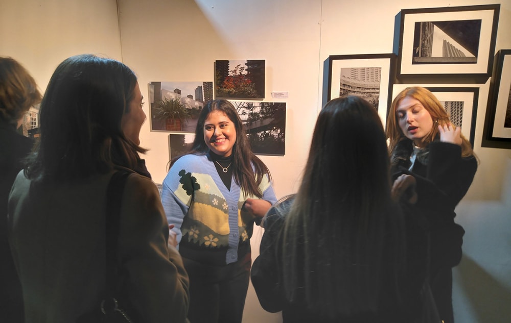 A crowd of students view exhibited work.