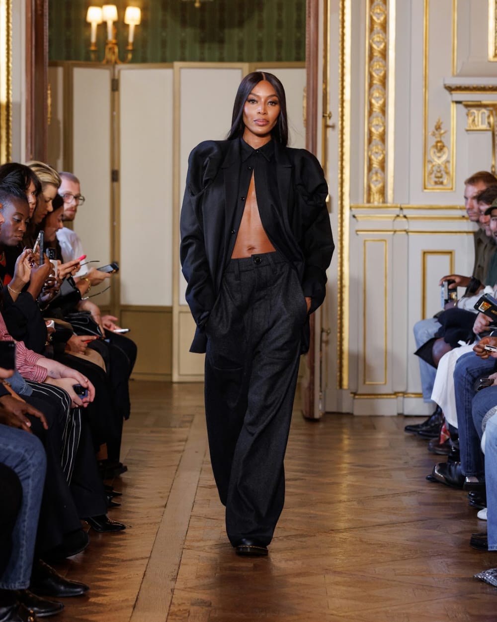 Naomi Campbell walking on runway show.