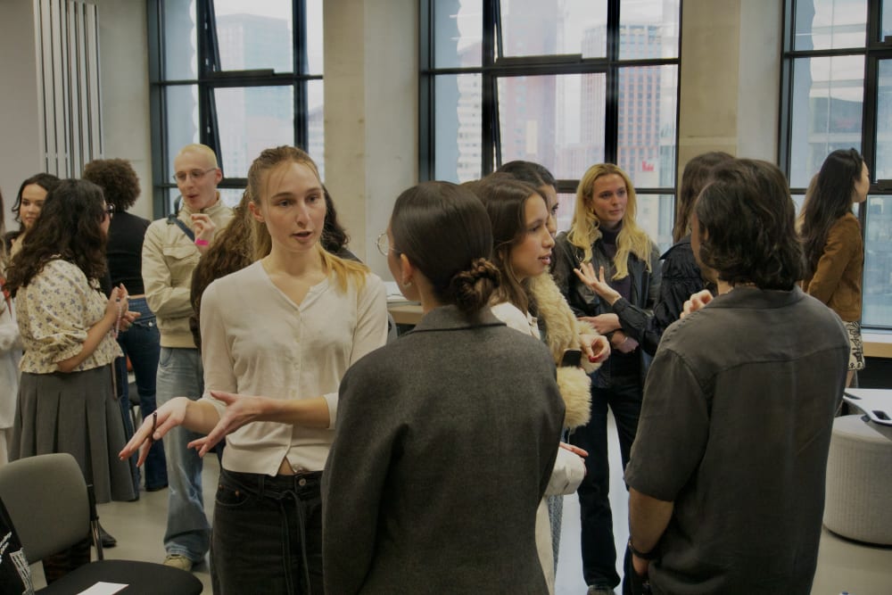 Student talking to a panellist in a networking session in a classroom.