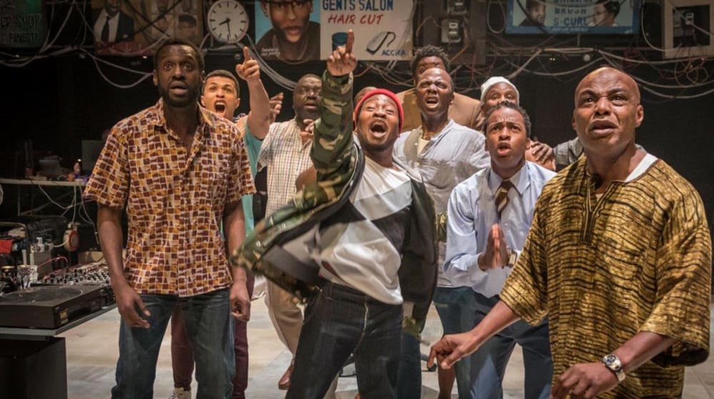 Shot of a group of performers in Barber Shop Chronicles at The National Theatre