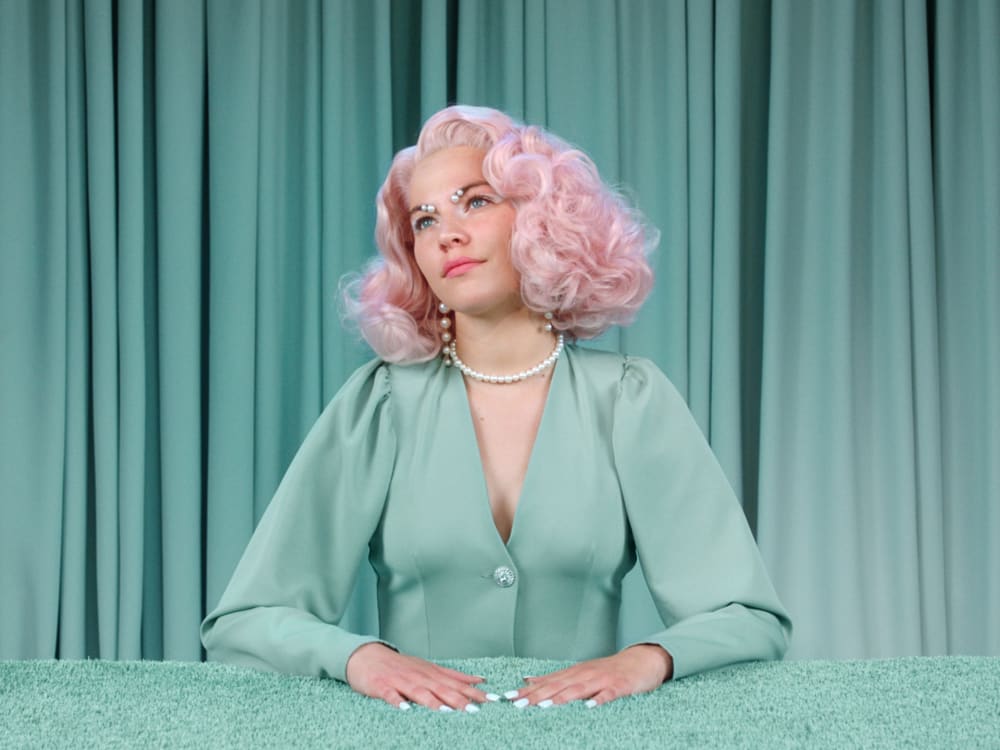 Lady with blonde wearing a green suit