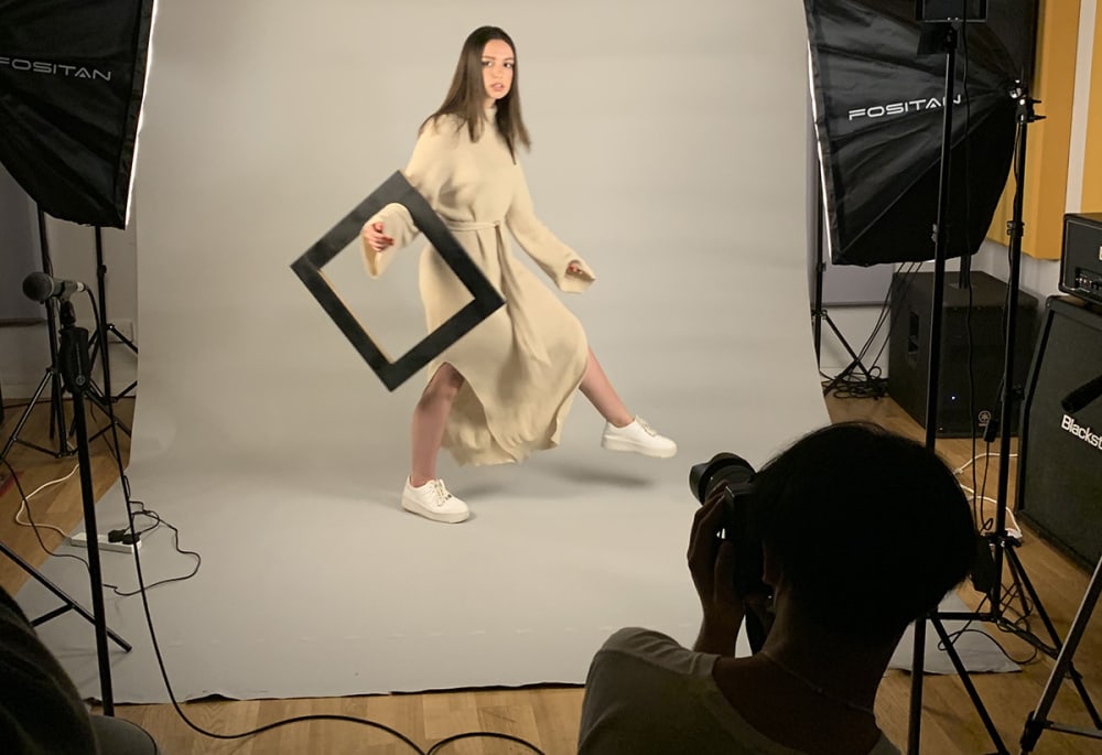 Behind-the-scenes photograph of a model holding a photoframe.