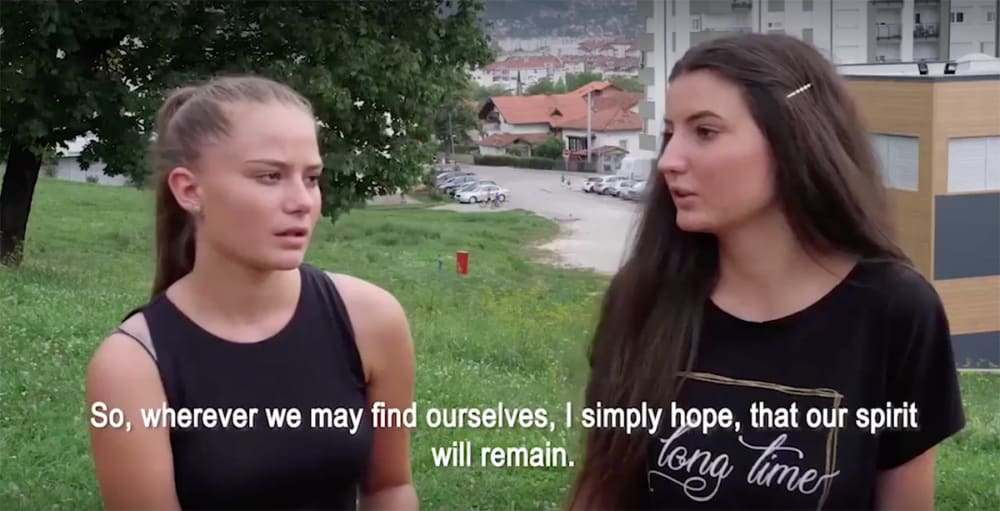 A still from a film depicting two girls in conversation.