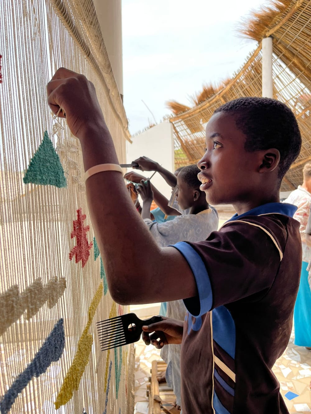 people weaving thread onto a loom