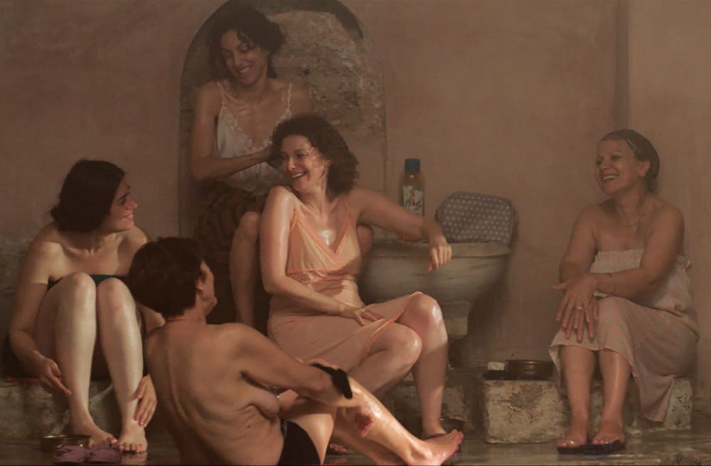 A film still of women in a public bath.