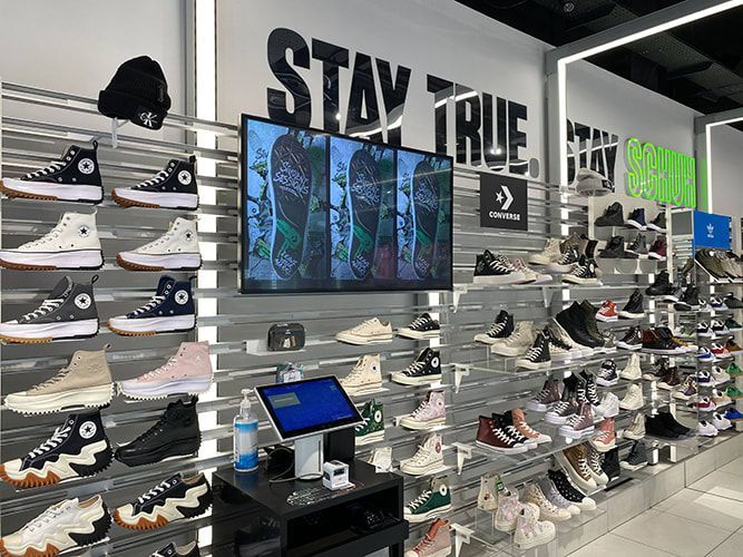 Sneakers displayed at a store on a wall.