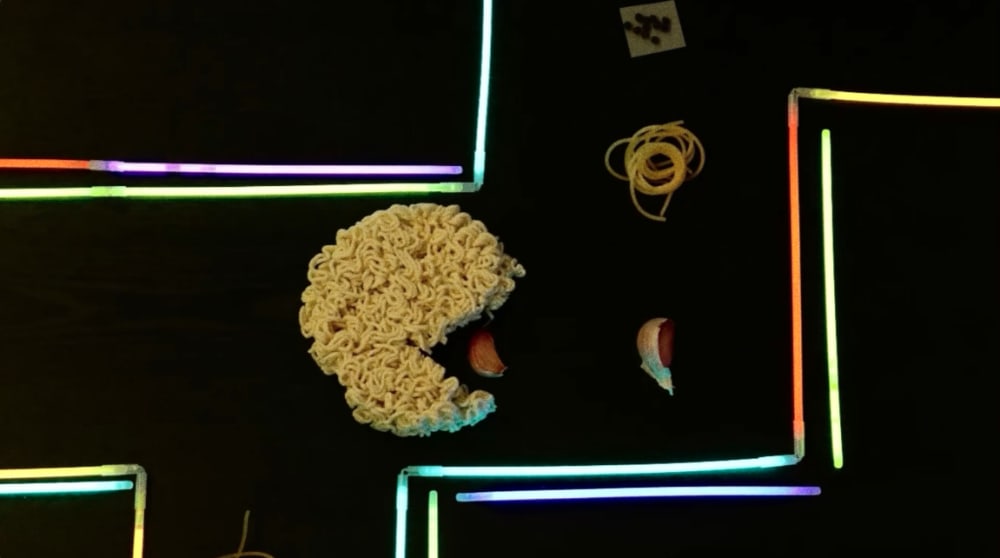 Screenshot of an animation depicting a pac-man shaped ramen eating pieces of garlic