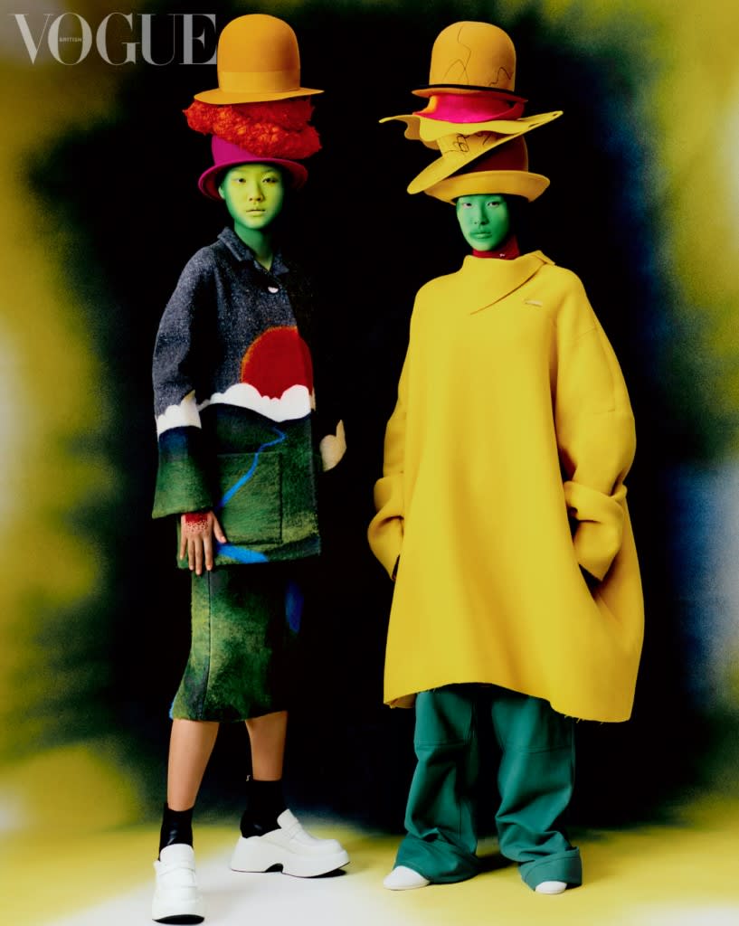Photoshoot by Holmes Production. Two models stand looking into the camera, wearing digitally enlarged clothes in tones of yellow and green