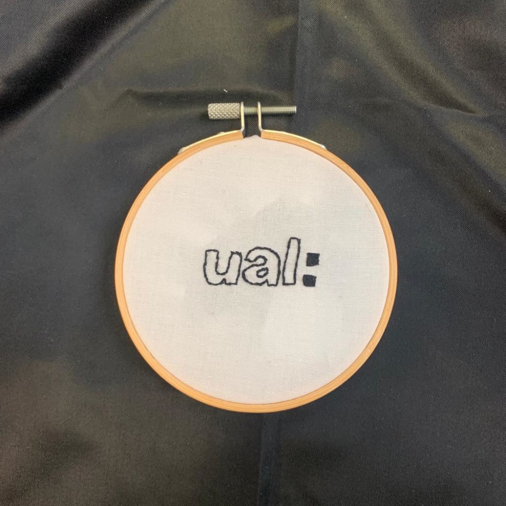 an embroidery hoop with UAL embroidered onto the fabric