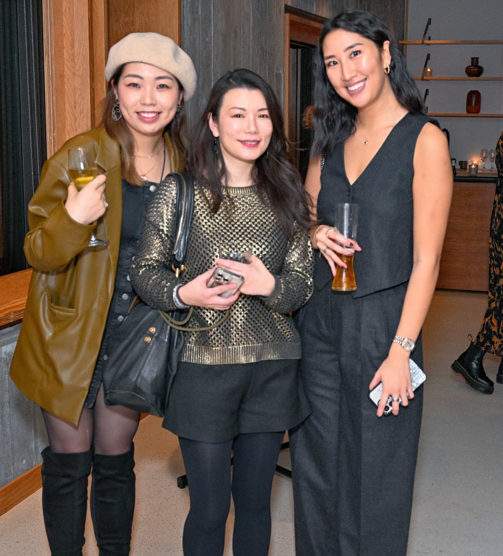 Three guests at the reception smiling to camera