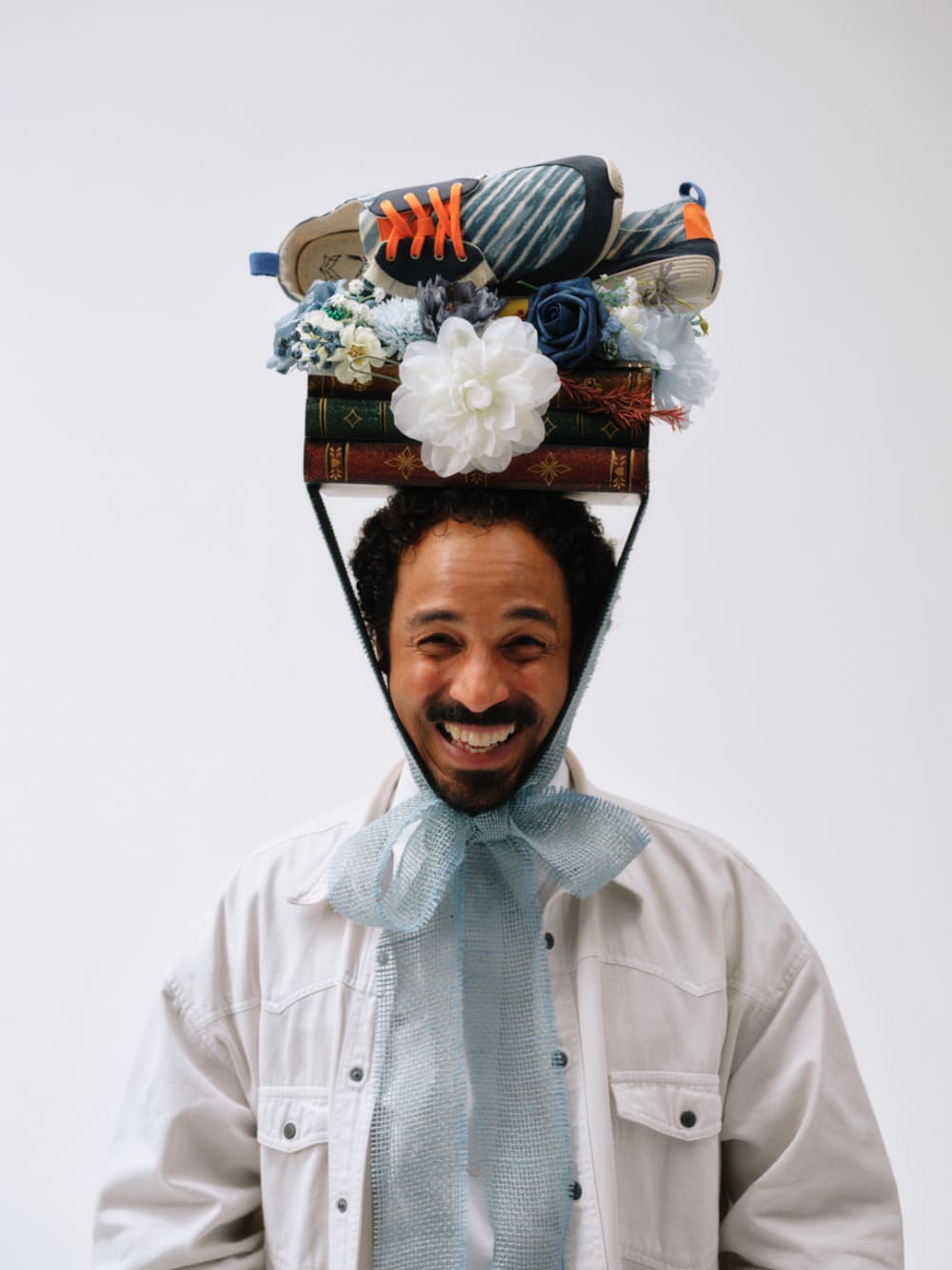 Person with shoes and books balancing on head