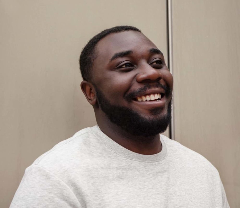 Aaron Reid in a white t-shirt looking to the right of the camera