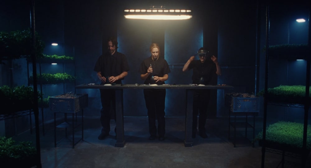 Movie scene representing three people in a dark room