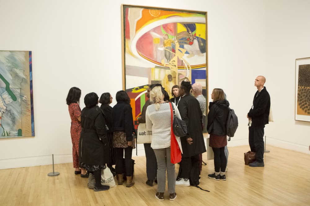 People gathered around a painting at an exhibition