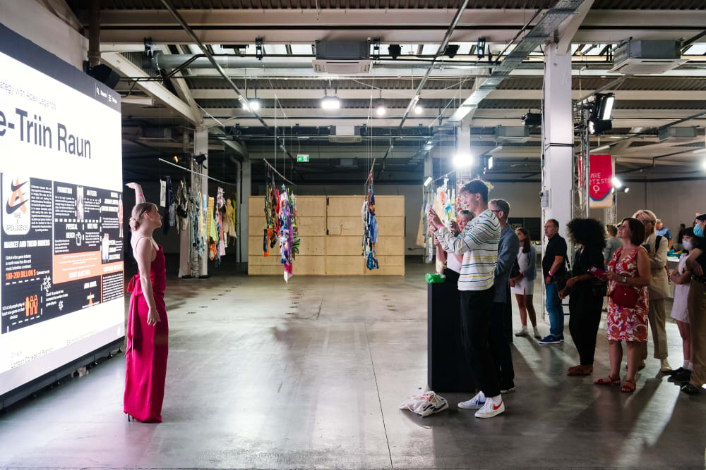 Girl posing in front of presentation whilst friend takes picture