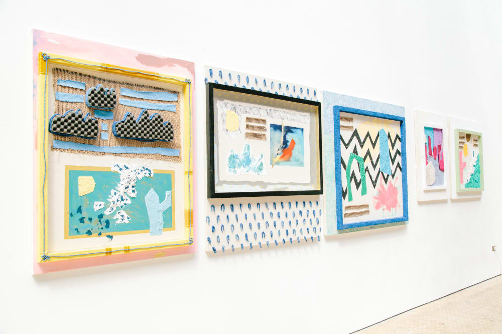 Selection of mixed media pictures hanging on a wall