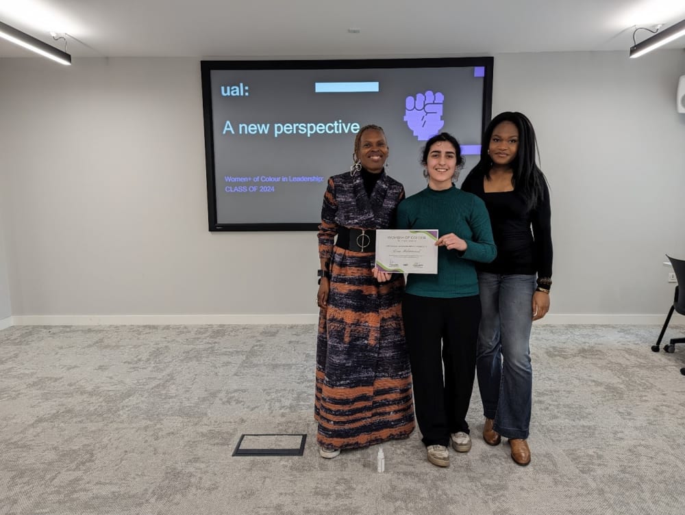 Lena poses for a photo holding up a certificate acknowledging her participation in the Creative Shift programme