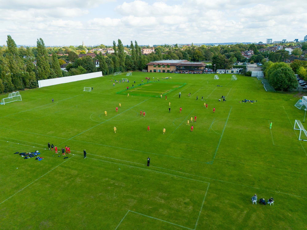 A drone shot of a football pitch, with 2 teams playing a game of football.