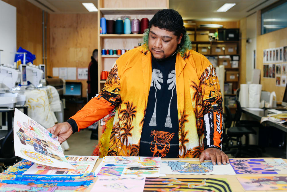 Man looking at fashion illustrations and swatches