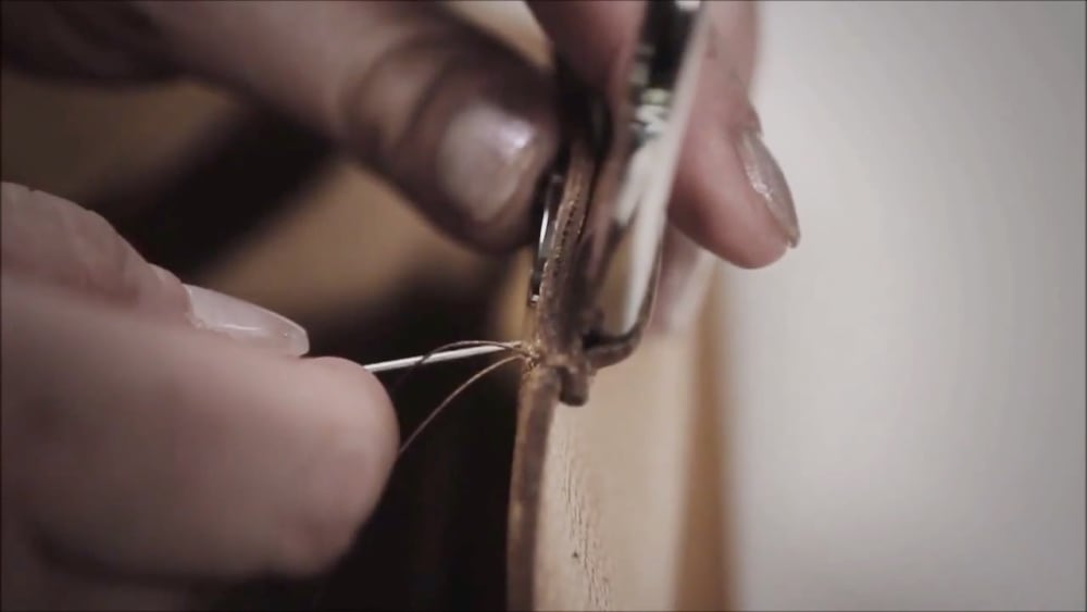 Woman's hands crafting leather goods