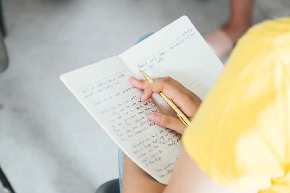 Student writing on notebook.