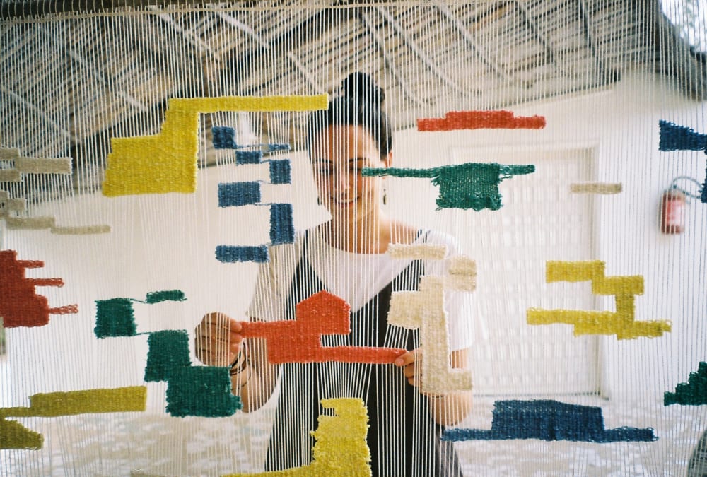 a woman that can be seen through a loom