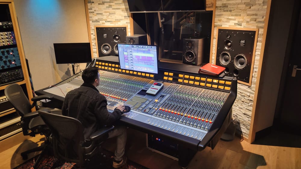 luigino sitting at a mixing console in his studio