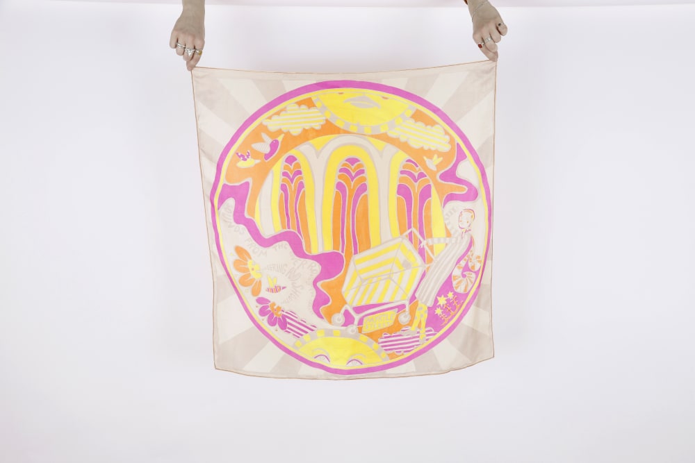 Photograph of hands holding a printed silk scarf