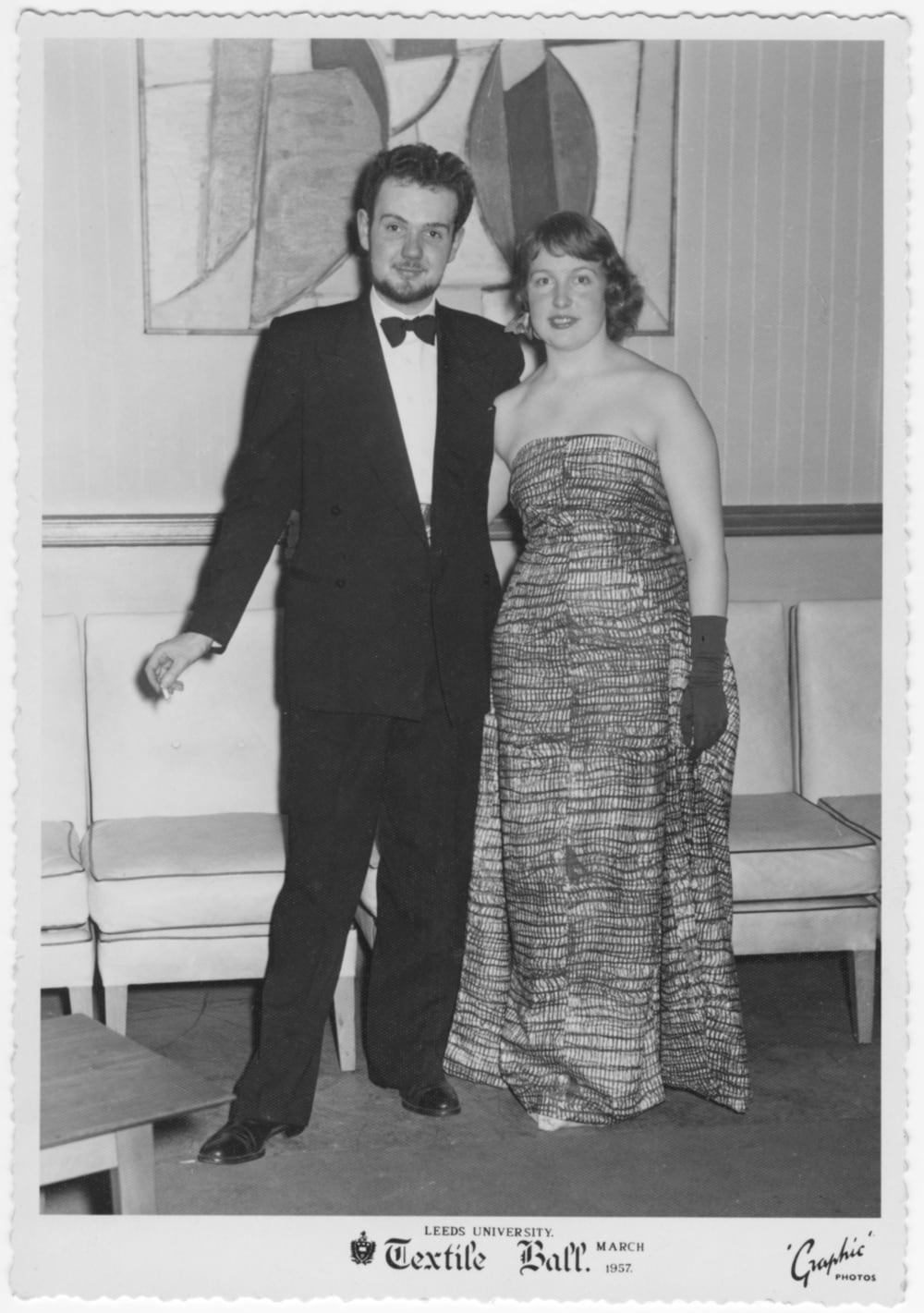 A man and a woman dressed up in a suit and dress