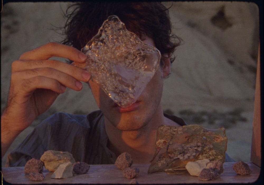 model holding diamond shaped crystal in front of face