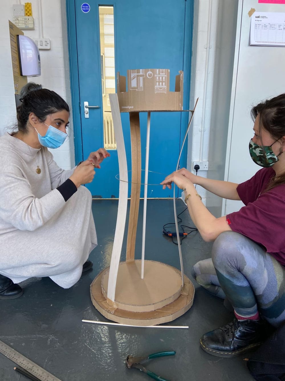 a photograph of a scene in BA Theatre Design’s Macbeth interpretation. Red lighting is showing silhouettes of the actors of stage. 